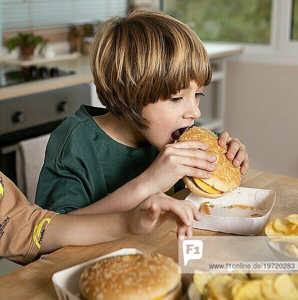 Kind ißt Burger zu Hause