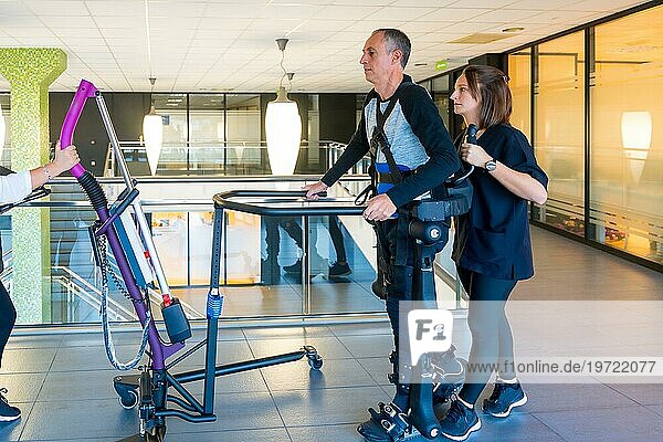 Mechanisches Exoskelett. Physiotherapeutin hilft behinderter Person mit Roboterskelett beim Gehen. Futuristische Rehabilitation  Physiotherapie in einem modernen Krankenhaus