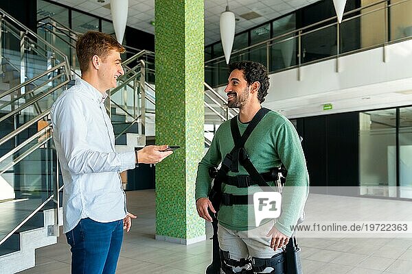 Mechanisches Exoskelett  Physiotherapeut mit Blick auf Konsultation mit Tablette mit behinderter Person mit Roboterskelett  Physiotherapie im modernen Krankenhaus  futuristische Physiotherapie