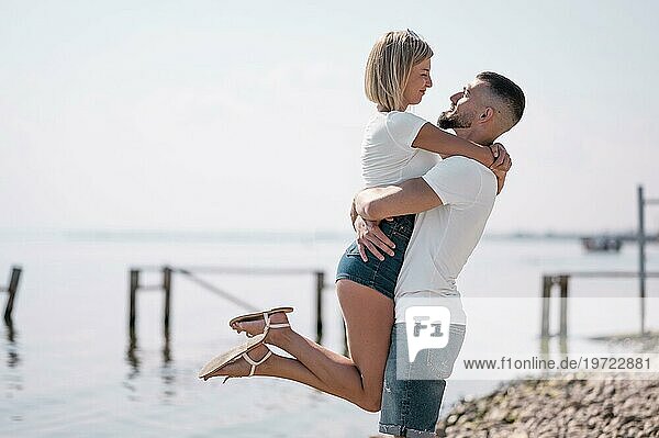 Glückliches Paar hängt zusammen am Strand ab