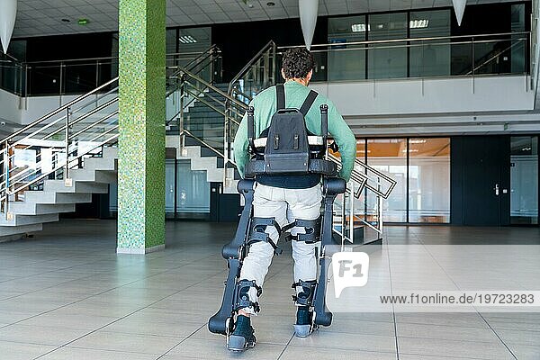 Mechanisches Exoskelett  behinderte Person auf dem Rücken  die mit Hilfe eines Roboterskeletts geht  Physiotherapie in einem modernen Krankenhaus  futuristische Physiotherapie