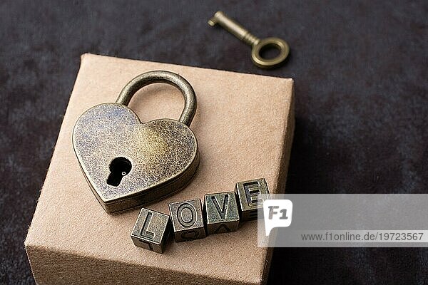 Vorhängeschloss in Form einer Liebe  Schlüssel und Aufschrift Liebe auf der Schachtel