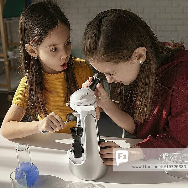 Mittlere Aufnahme Mädchen lernen mit Mikroskop