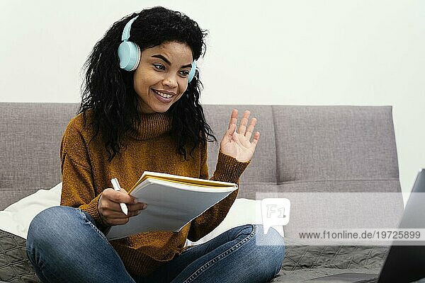 Teenage girl using laptop headphones online school