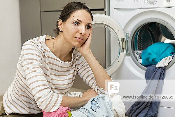 Müde Frau beim Wäschewaschen