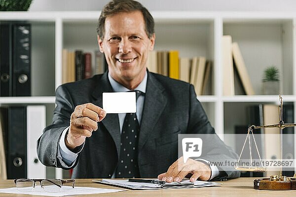 Lächelnd reifen Anwalt zeigt leere Visitenkarte sitzen Gerichtssaal