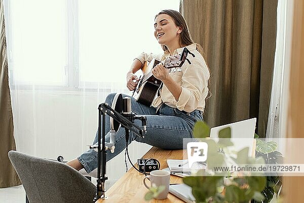Seitenansicht weibliche Musikerin zu Hause spielen akustische Gitarre singen