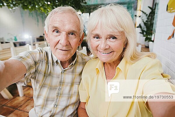 Erfreut Senior Paar umarmt sitzen Café schießen selfie