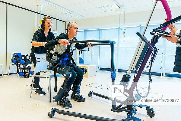 Mechanisches Exoskelett. Weibliche Physiotherapie medizinische Assistentin hebt behinderte Person mit Roboterskelett. Futuristische Rehabilitation  Physiotherapie in einem modernen Krankenhaus