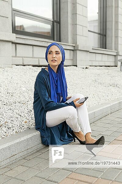 Wunderschönes Mädchen mit Hidschab im Freien sitzend