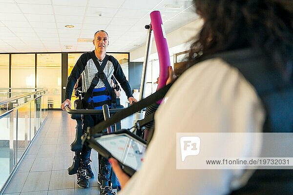 Mechanisches Exoskelett. Physiotherapeutin hilft behinderter Person mit Roboterskelett beim Gehen. Futuristische Rehabilitation  Physiotherapie in einem modernen Krankenhaus