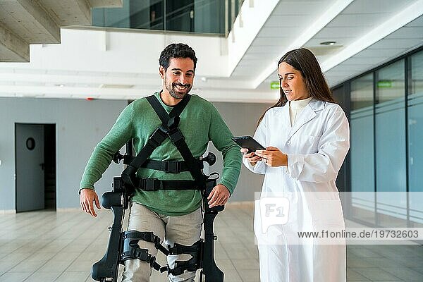 Mechanisches Exoskelett  Ärztin Physiotherapeutin mit behinderter Person mit Roboterskelett in der Rehabilitation  Physiotherapie in einem modernen Krankenhaus  futuristische Physiotherapie