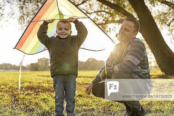 Vater und Sohn spielen zusammen mit einem bunten Drachen