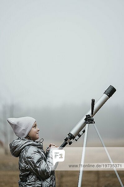Seitenansicht kleines Mädchen mit Teleskop