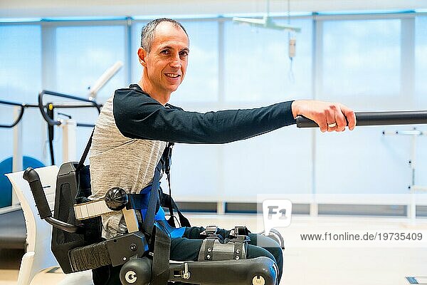 Mechanisches Exoskelett. Porträt einer behinderten Person mit Roboterskelett in der Rehabilitation  die versucht  allein aufzustehen  Physiotherapie in einem modernen Krankenhaus