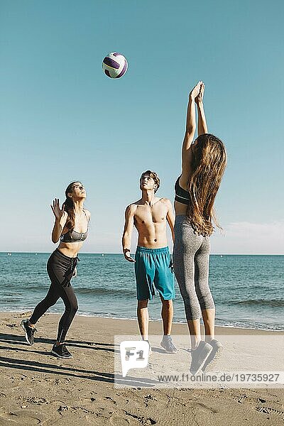 Gruppe Freunde spielen Volleyball am Strand