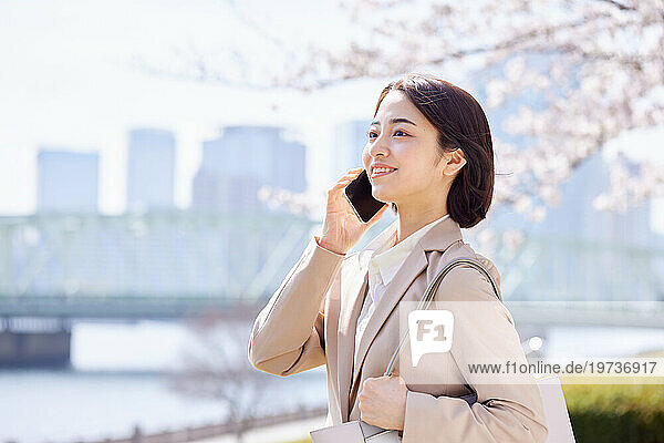 Young Japanese woman with smartphone outside