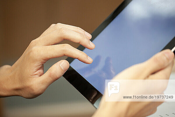 Close-up of unrecognizable person hands using digital tablet