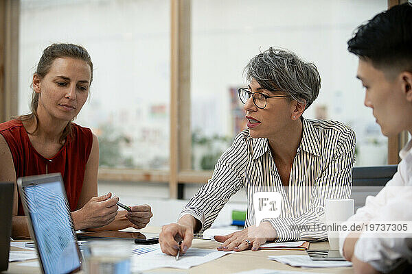 Businesswoman discussing project with coworkers
