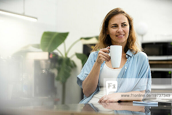 Female entrepreneur having a coffee break at office