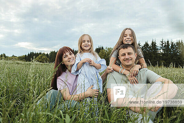 Happy parents with daughters in field