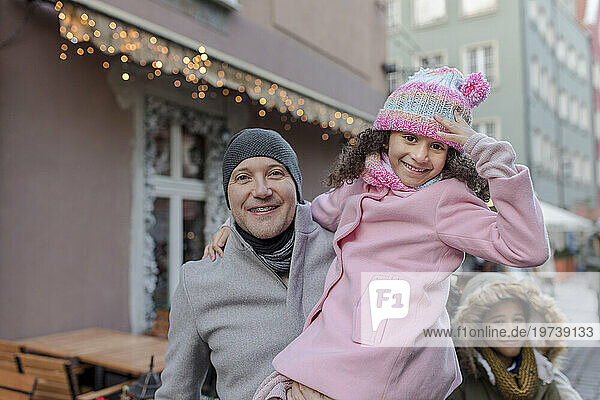 Smiling girl with father and brother at Christmas market
