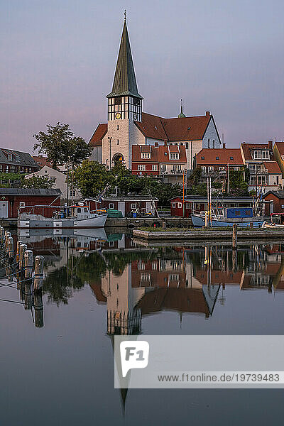 Denmark  Bornholm  Ronne  St Nicholas Church reflecting in coastal water at dusk