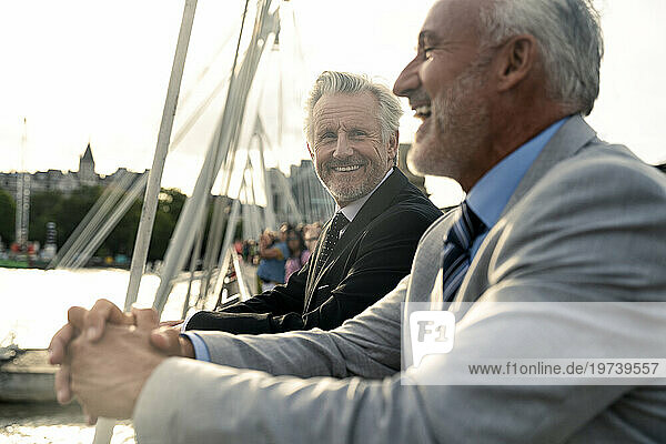 Happy businessman standing with colleague on bridge
