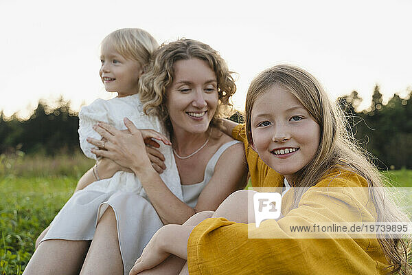 Smiling mother and daughters spending leisure time with each other