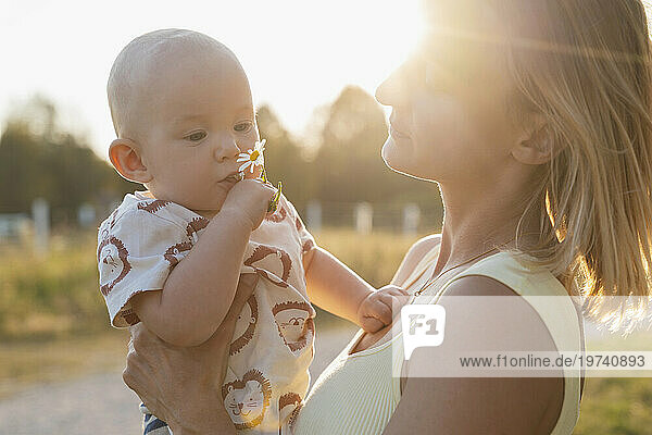 Mother spending leisure time with son in park at sunset