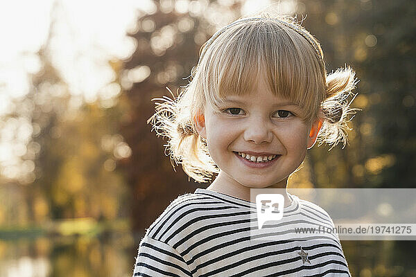 Smiling cute blond girl on sunny day
