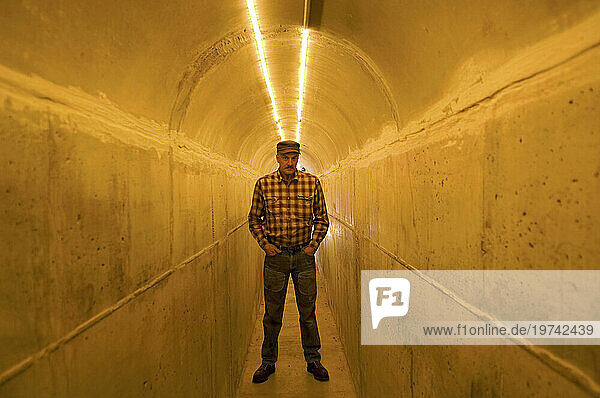 Man stands in a tunnel illuminated with light; Lincoln  Nebraska  United States of America