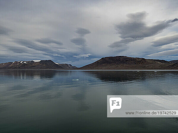 Overcast skies over Spitsbergen and the calm water of the sound; Spitsbergen  Svalbard  Norway