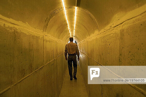 Man walks through a concrete tunnel leading to his garage; Lincoln  Nebraska  United States of America