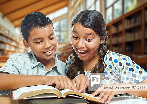 Zwei hispanische Schüler haben Spaß beim Lernen in einer Schulbibliothek