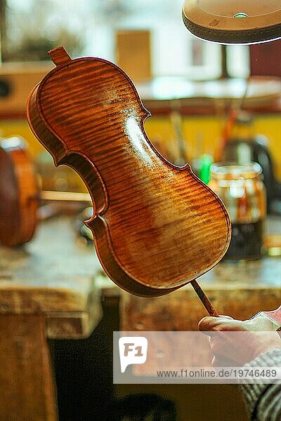 Senior Experte Geigenbauer Geigenbauer Lack mit Pinsel klassische handgefertigte Geige Farbe natürliche Zutaten Rezept in Cremona Italien Heimat der besten Handwerker dieser Art  selektiver Fokus  Bokeh