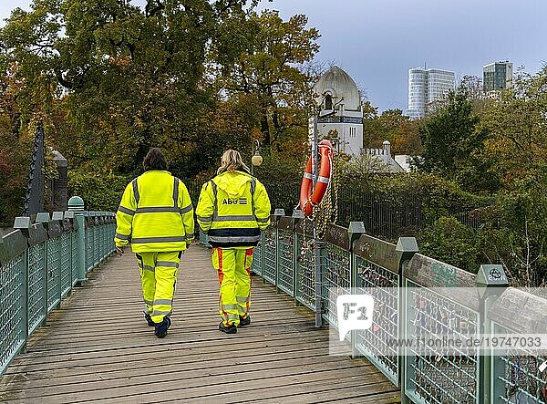 Zwei Personen in gelber Schutzkleidung  Brücke im Tiergartenpark  Berlin  Deutschland  Europa