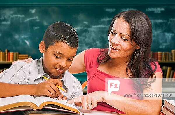 Eine Lehrerin unterrichtet einen jungen hispanischen Jungen im Klassenzimmer