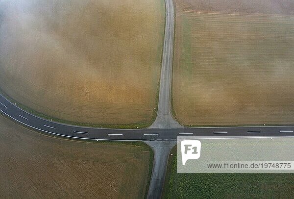 Drohnenansicht einer in dichten Morgennebel gehüllten ländlichen Landschaft mit Strassenkreuzung bei Prambachkirchen  Hausruckviertel  Oberösterreich  Österreich  Europa