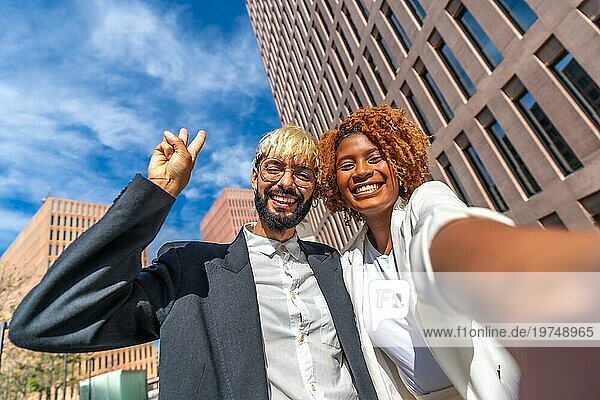 Frontalaufnahme von zwei jungen multiethnischen Geschäftsleuten  die ein Selfie im Freien machen