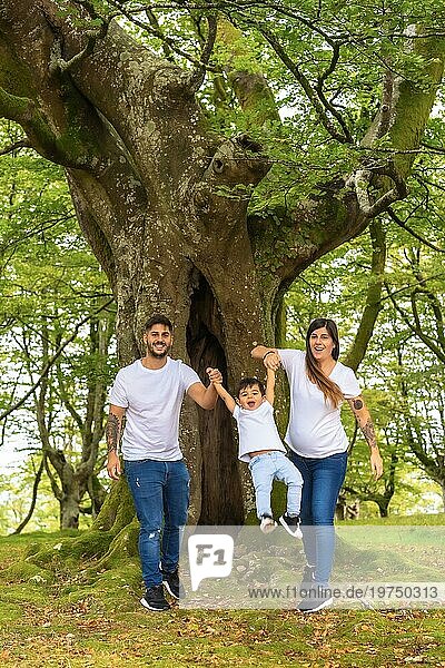 Vertikales Foto einer verspielten Familie  die gemeinsam Zeit in einem Wald verbringt