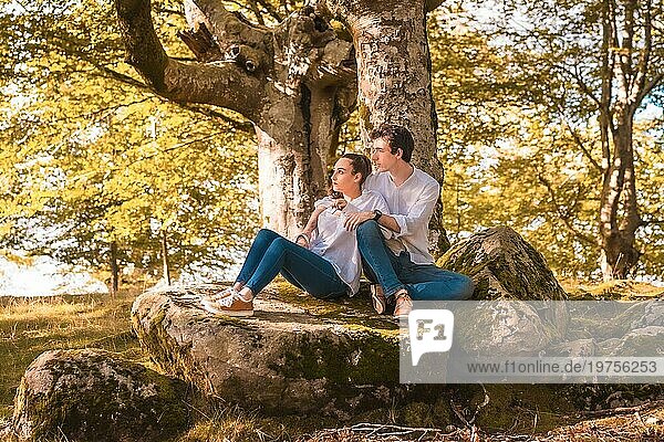 Horizontales Foto mit Kopierbereich einer romantischen Szene eines Paares  das im Wald sitzt