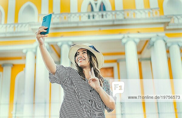 Junge Touristin mit Hut macht ein Selfie auf einem Platz. Selfies und Urlaub Konzept. Schöne Tourist Mädchen nehmen Selfie in der Kathedrale von Granada