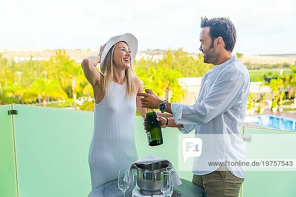 Ein frisch verheiratetes Paar feiert seine Flitterwochen mit Champagner auf der Terrasse eines Hotels