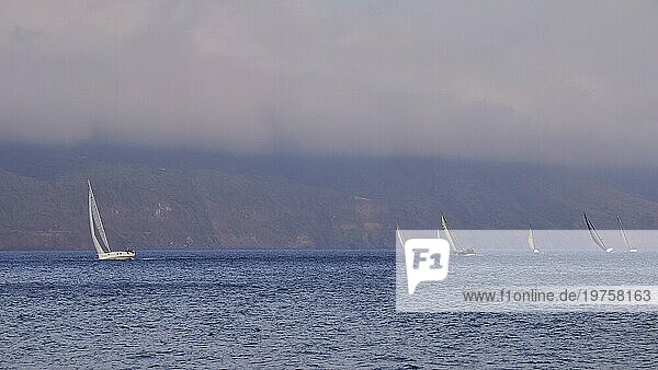 Segelboote  Segelregatta  Küste Liparis  tiefhängende Wolken  Lingua  Südostspitze der Insel  Salina  Äolische Inseln  Liparische Inseln  Sizilien. Italien