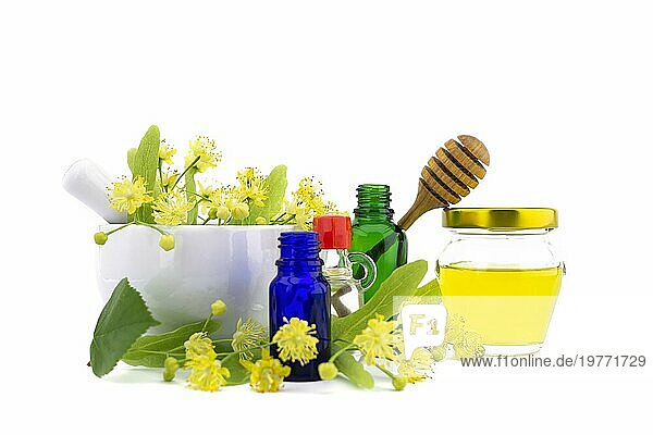 Frische Linde (Tilia) oder Blüten und Blätter mit einer Flasche Honig und Flaschen mit ätherischen Ölen in einem therapeutischen Stillleben für alternative Heilmethoden