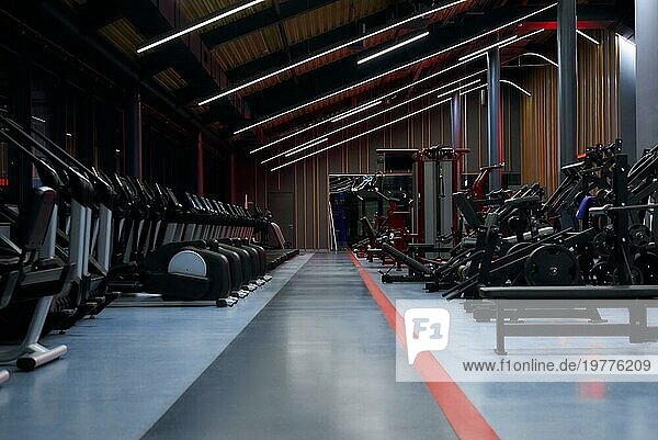 Modernes Fitnessstudio. Sportgeräte in der Turnhalle. Langhanteln mit verschiedenen Gewichten auf einer Ablage. Gemischte Medien