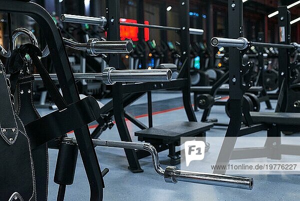 Modernes Fitnessstudio. Sportgeräte in der Turnhalle. Langhanteln mit verschiedenen Gewichten auf einer Ablage. Gemischte Medien