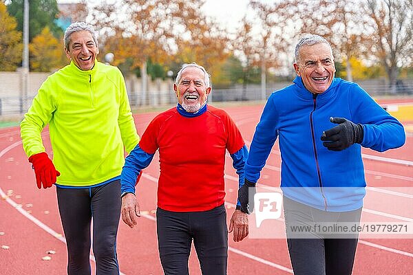 Müde ältere Männer nach einem Lauf auf einer Freiluft Leichtathletikbahn im Winter
