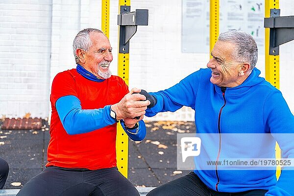 Ältere Männer amüsieren sich gemeinsam auf einem Sportplatz und beglückwünschen sich selbst